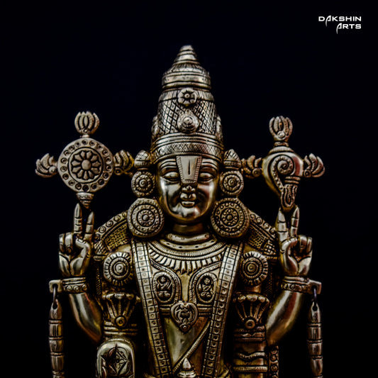 Closeup of a Balaji's face in the brass Balaji Padmavati idol against a black background - Dakshin Arts
