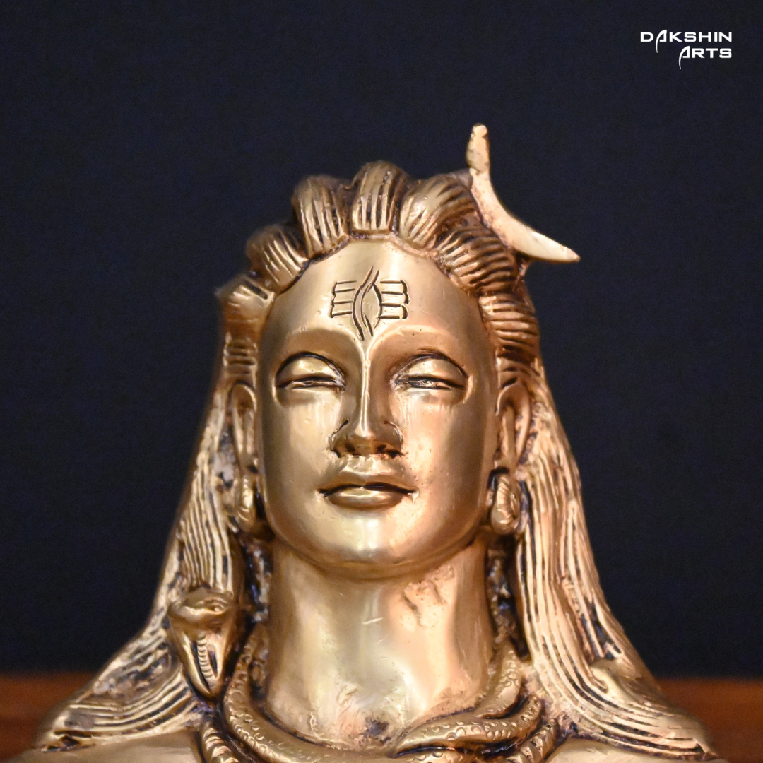 Front pose of Brass adiyogi with closed eyes, featuring a crescent on the head, against a dark background.