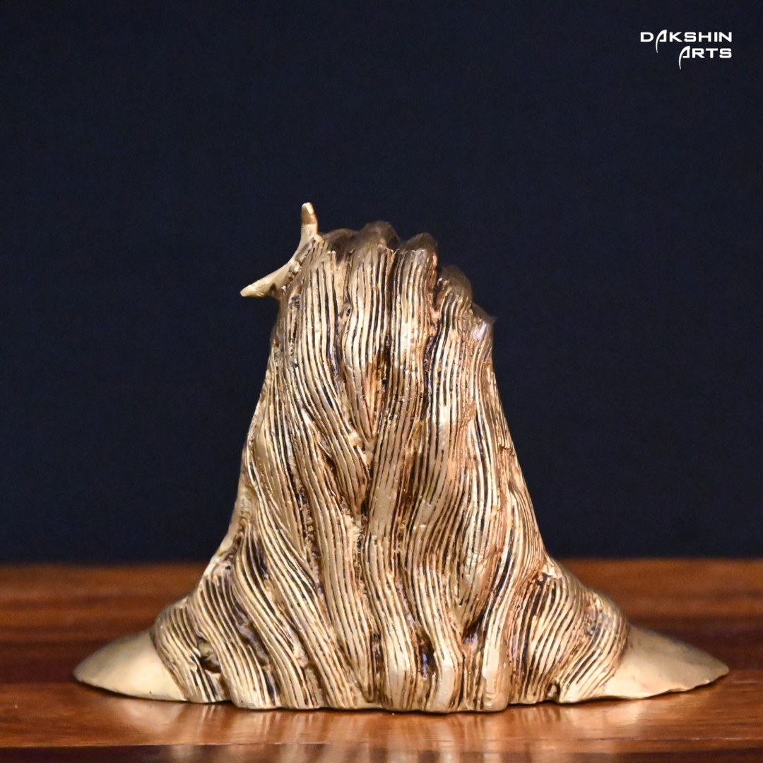 Back pose of Brass adiyogi with closed eyes, featuring a crescent on the head, against a dark background.
