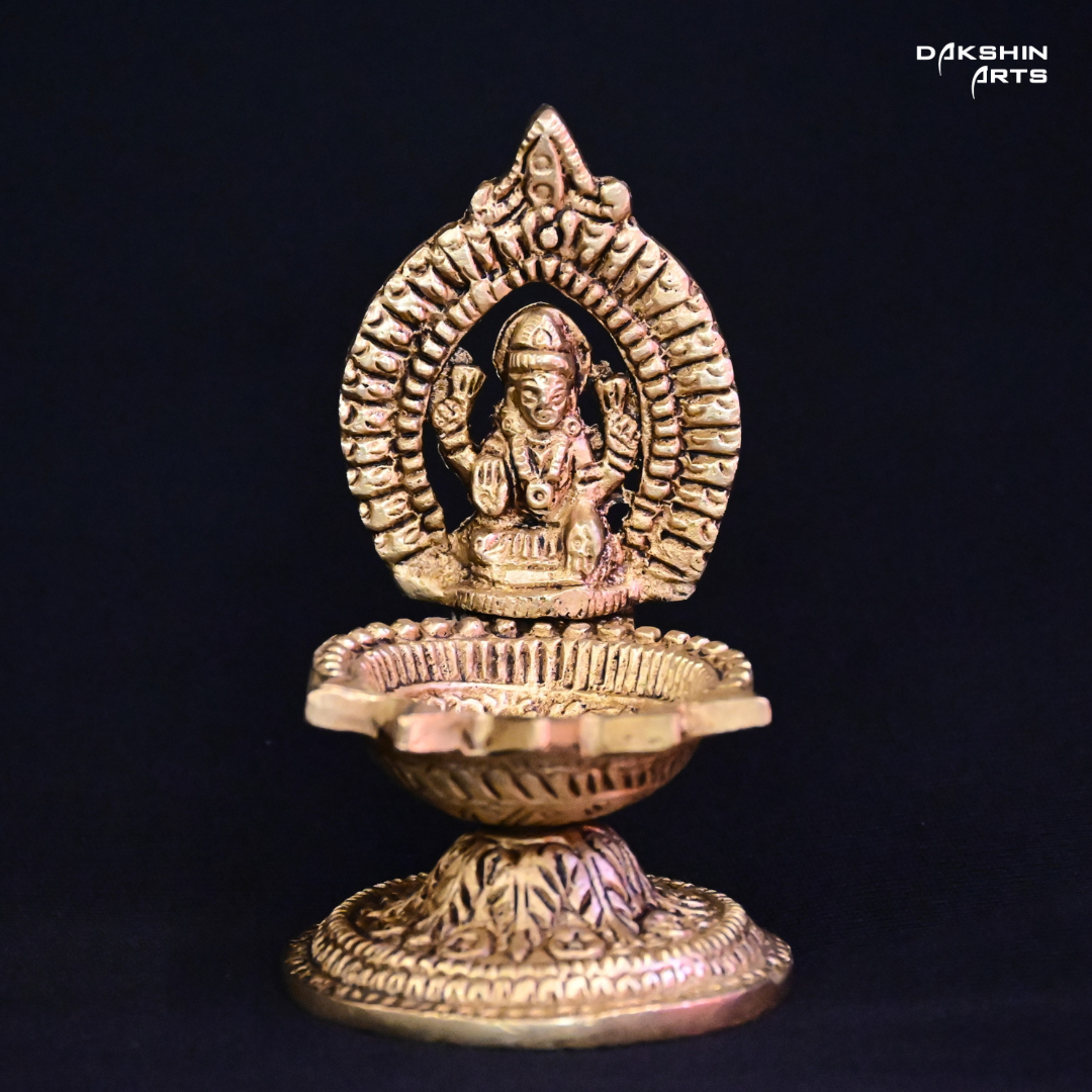 One ornate brass oil lamp with intricate carvings of Laxmi - Dakshin Arts