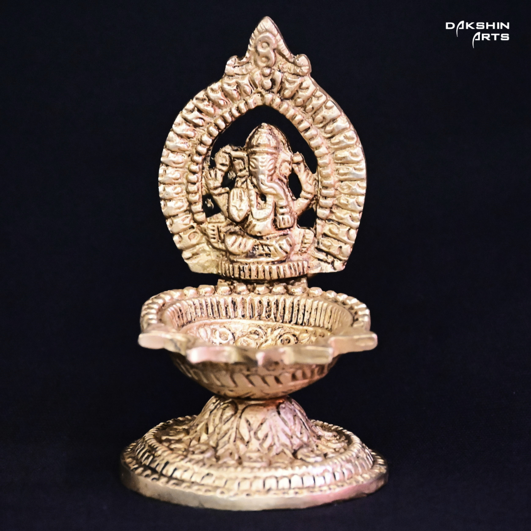 One ornate brass oil lamp with intricate carvings of Ganesha - Dakshin Arts