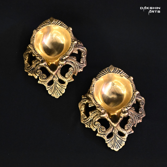 Two ornate brass diyas, intricately designed, showcasing traditional craftsmanship and elegance- Dakshin Arts