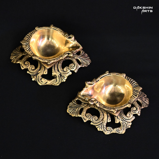 Two ornate brass diyas, intricately designed, showcasing traditional craftsmanship and elegance- Dakshin Arts