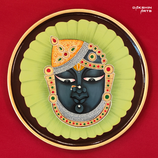 A round wooden Pichwai wall painting with Srinathji on a green leaf background - Dakshin Arts