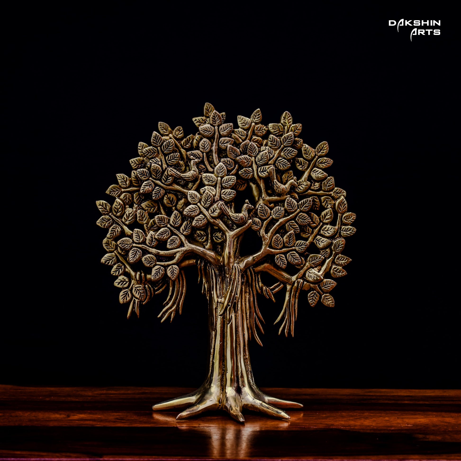 A brass tree sculpture with intricate leaf details on a dark background, conveying elegance and artistry- Dakshin Arts