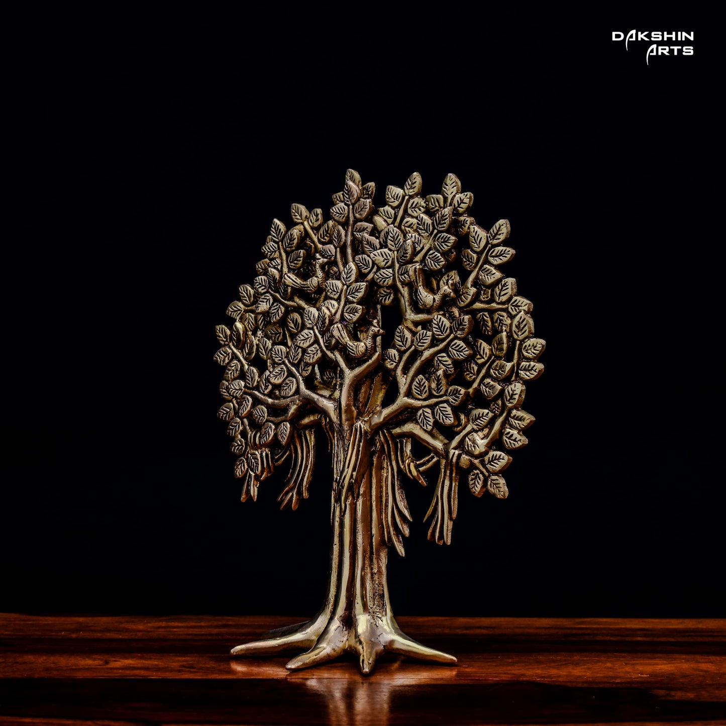 A brass tree sculpture with intricate leaf details on a dark background, conveying elegance and artistry- Dakshin Arts