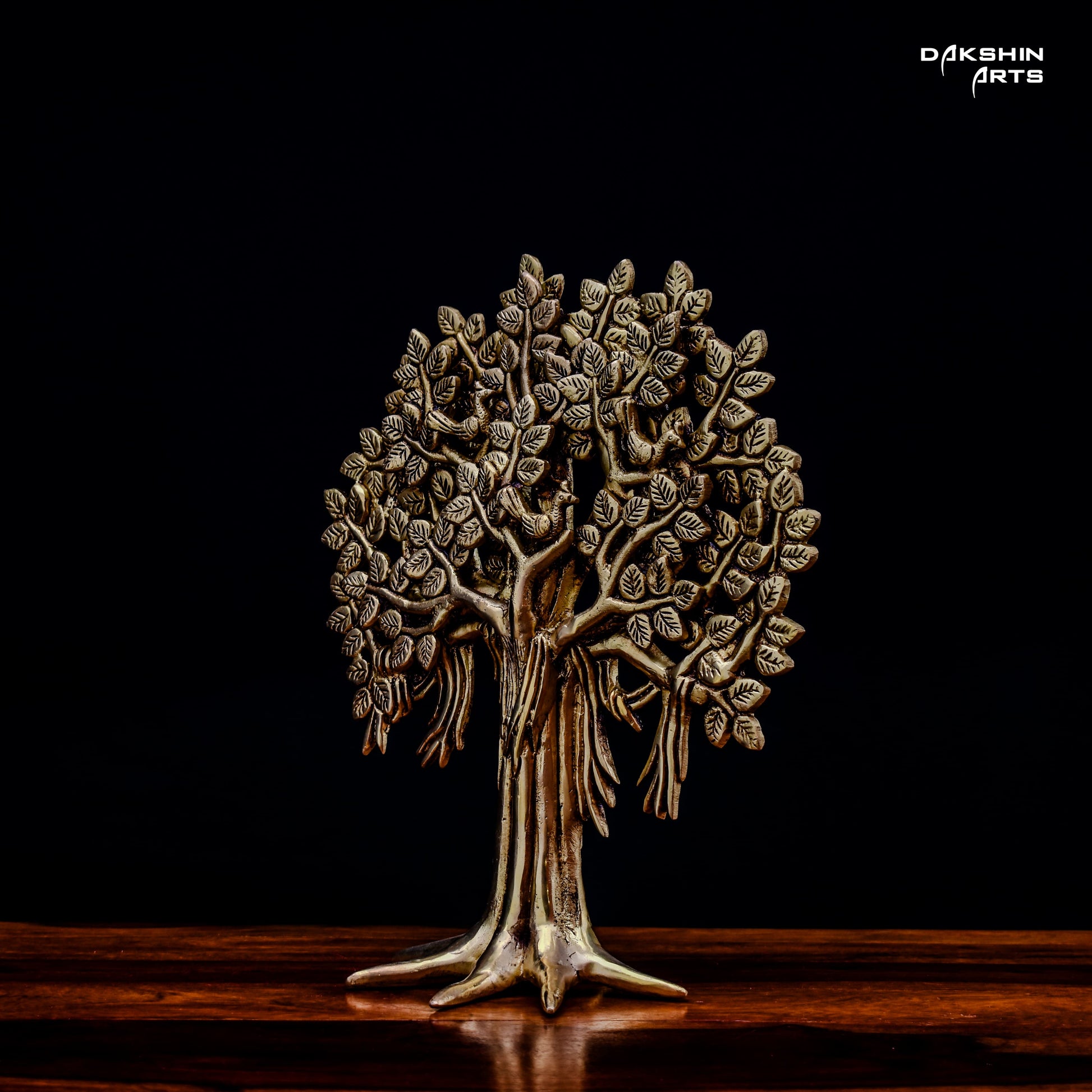 A brass tree sculpture with intricate leaf details on a dark background, conveying elegance and artistry- Dakshin Arts
