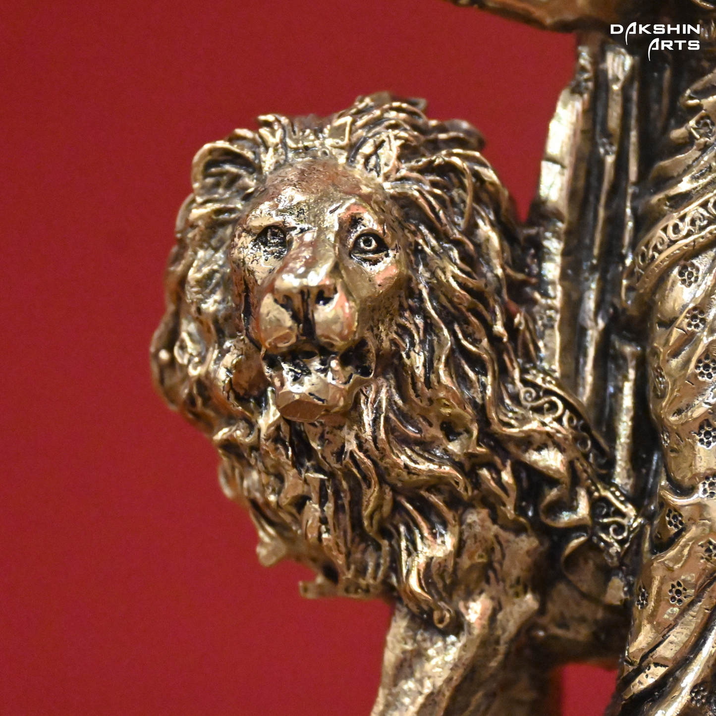 Brass lion statue against a red background