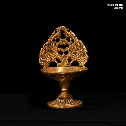 Decorative gold lamp with intricate design on a black background, branded 'Dakshin Arts'.