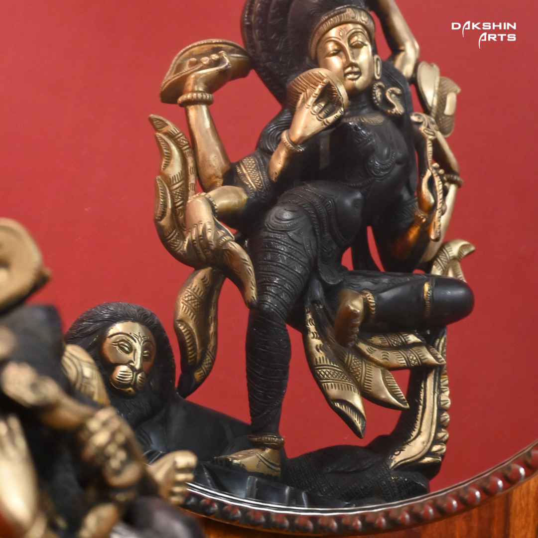 A black gold colored statue of Ardhanareshwar adorned with detailed patterns, with a lion at the base- Dakshin Arts