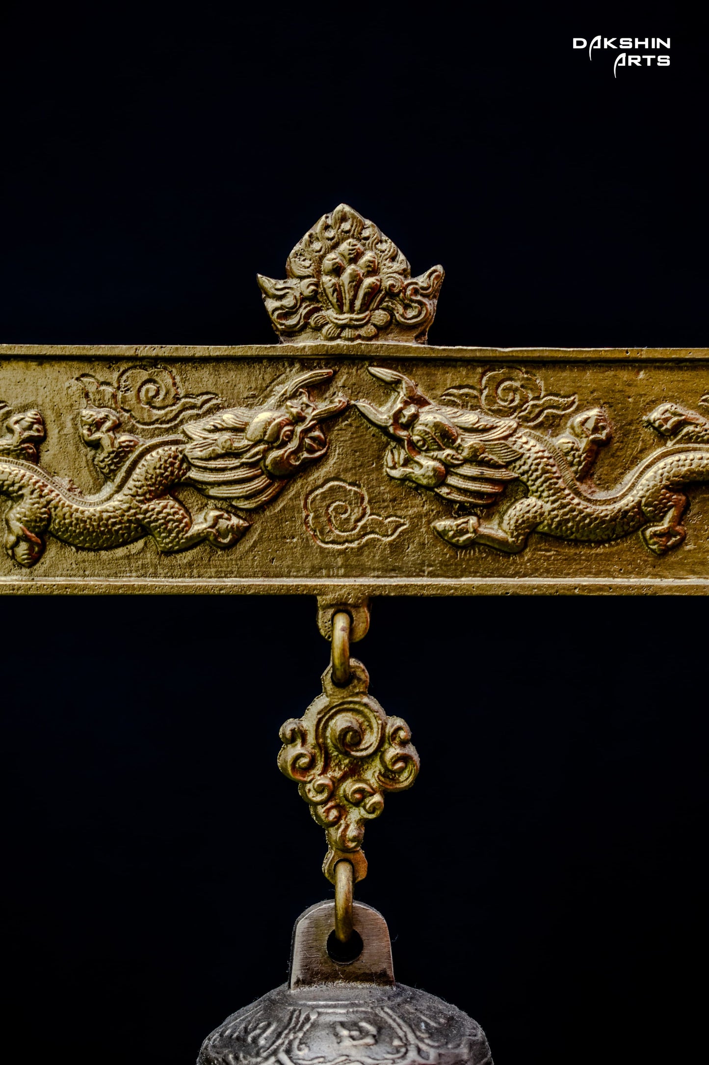 Close-up of the wooden frame with intricate designs from which the bell ishanging- Dakshin Arts