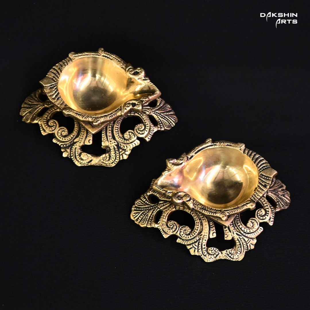  Two ornate brass diyas, intricately designed, showcasing traditional craftsmanship and elegance- Dakshin Arts